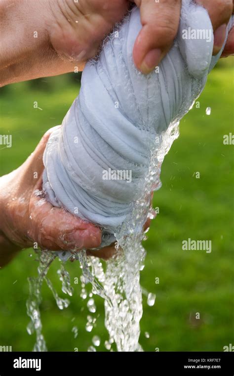 Hands squeeze wet cloth Stock Photo - Alamy