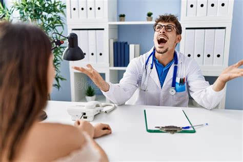 Young Doctor With Client At Medical Clinic Crazy And Mad Shouting And