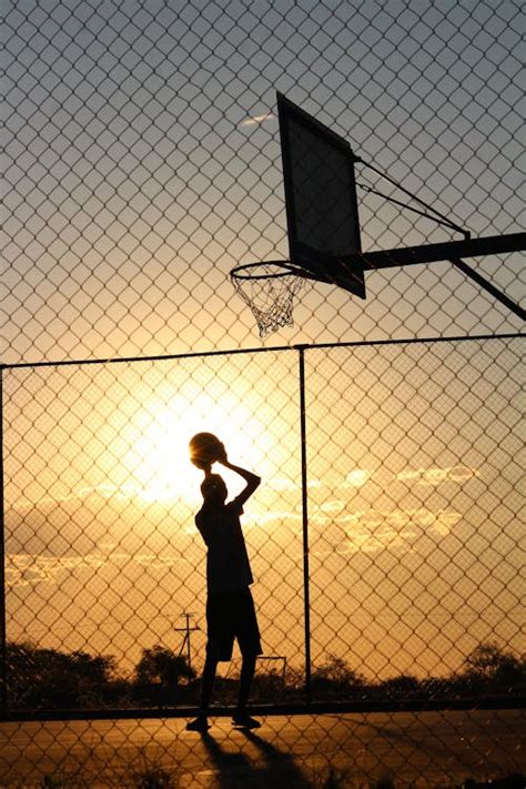 Basketball player throwing ball into basketball hoop · Free Stock Photo