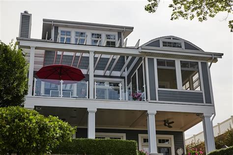 Premium Photo Modern Beach House With Red Umbrella And Pink Flowers