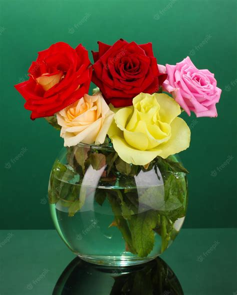 Premium Photo Beautiful Roses In Glass Vase On Green Background