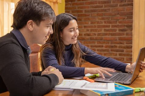 Chica latina y chico caucásico estudiando con una laptop Foto Premium