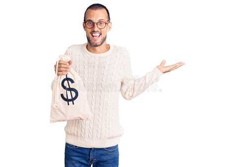 Young Handsome Man Holding Money Bag With Dollar Symbol Celebrating