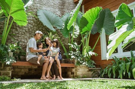 Retrato de familia asiática disfruta de su tiempo en el patio tropical