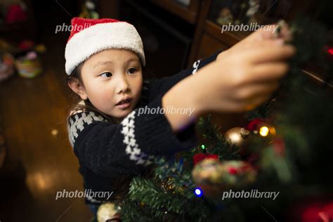 クリスマスツリーの飾りつけをする女の子 写真素材 [ 5806736 ] フォトライブラリー Photolibrary