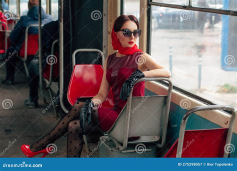 Stylish Woman In Sunglasses In A Red Dress Black Leather Gloves Tights Red Shoes And A Scarf