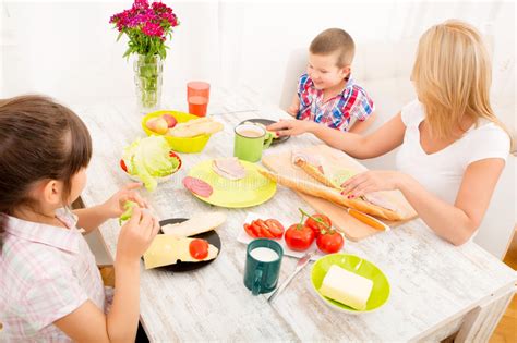 Familia Feliz Que Desayuna En Casa Imagen De Archivo Imagen De Mama