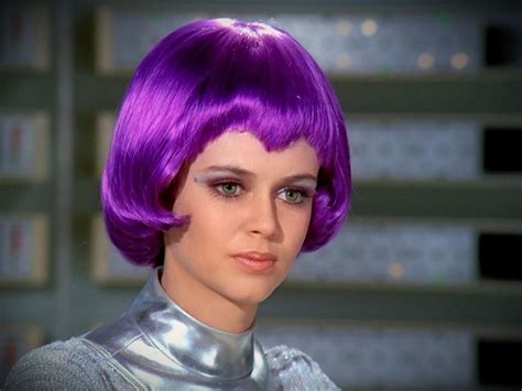 A Close Up Of A Person With Purple Hair Wearing A Silver Outfit And