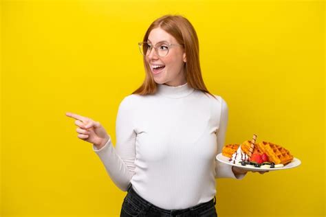 Mulher Jovem Ruiva Segurando Waffles Isolados Em Fundo Amarelo