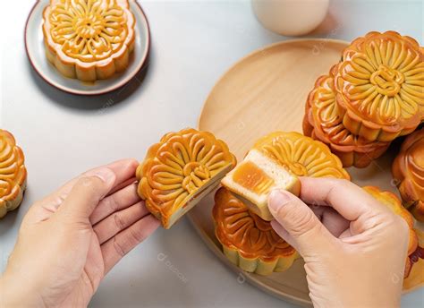 Mãos de pessoas comendo saborosos bolos redondos de lua no festival do