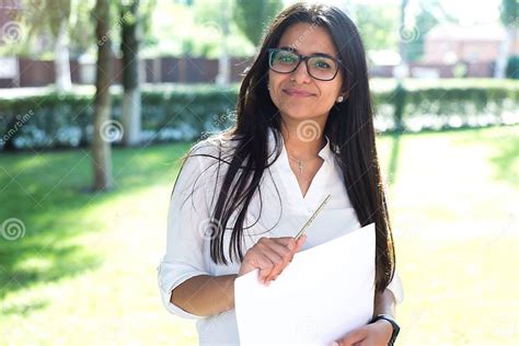 Portrait Of A Beautiful Indian Girl Business Woman In Glasses Holds