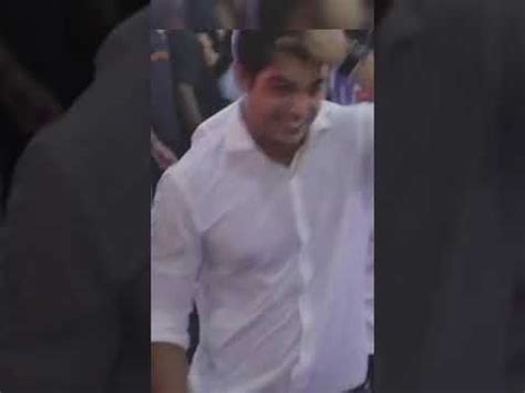 A Man In A White Shirt And Tie Is Walking Through The Crowd At An Event