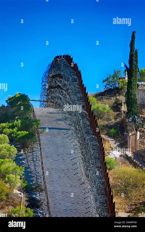 The US-Mexican border wall with layers of razor wire at Nogales AZ ...