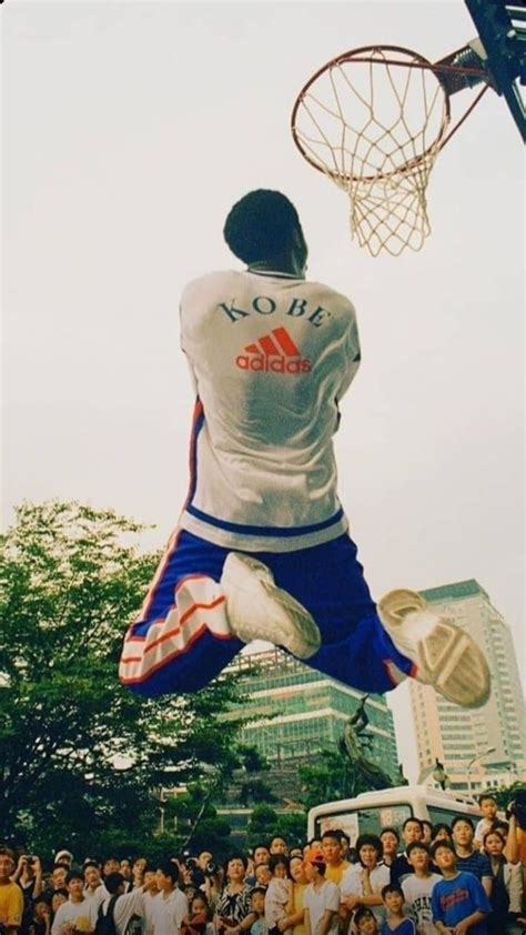 a man jumping up into the air to dunk a basketball in front of a crowd