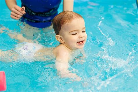 Um Menino De Anos Aprende A Nadar Em Uma Piscina Um Treinador