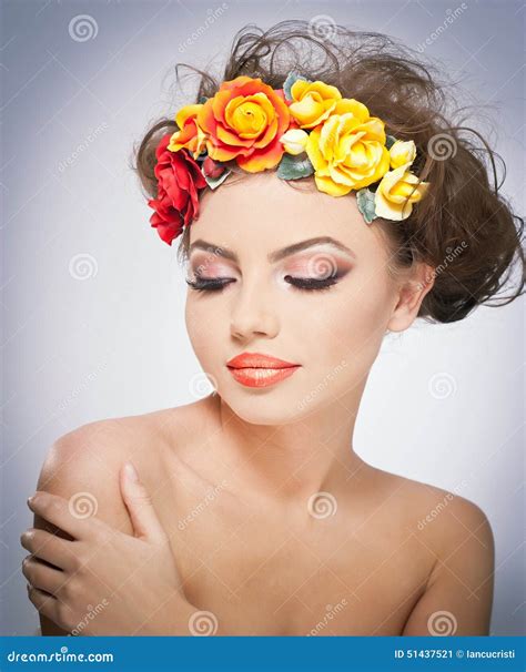 Portrait Of Beautiful Girl In Studio With Red And Yellow Roses In Her Hair And Naked Shoulders