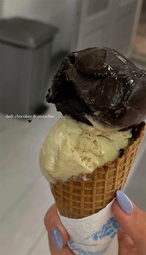 A Person Holding An Ice Cream Cone With Chocolate On Top