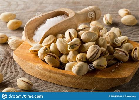 Heap Of Salted Roasted Green Pistachio Nuts Snack In Wooden Bowl On