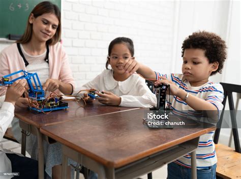 Happy African American Kid Boy Studying With Electric Robot And Friend