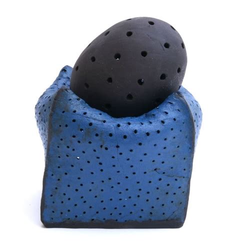 A Blue And Black Object Sitting On Top Of It S Back End With Holes In