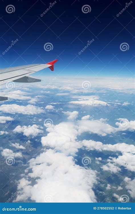 A View Through An Airplane Window Visible Wing Clouds Over Land And