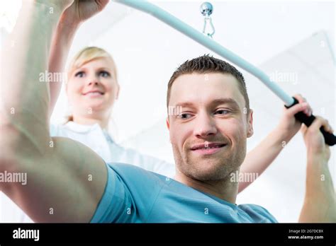 Patient At The Physiotherapy Doing Physical Exercises With Therapist In