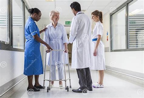 Senior Female Hospital Patient In Walking Frame Doctor Nurse Stock