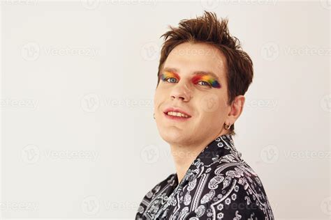 Jeune Homme Gay Est Debout Dans Le Studio Et Pose Pour Un Appareil Photo Maquillage Multicolore