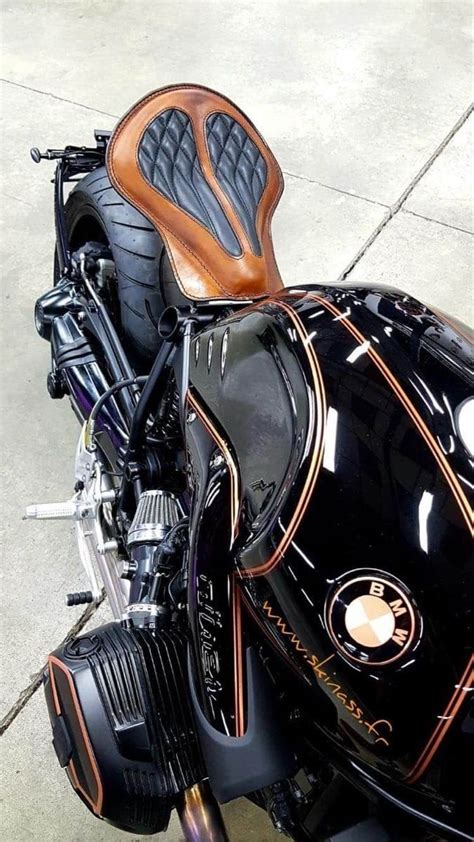 A Black And Brown Motorcycle Parked On Top Of A Sidewalk