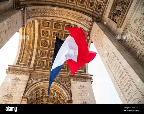 French flag waving under Arc de Triomphe in honor of VE day. Paris ...