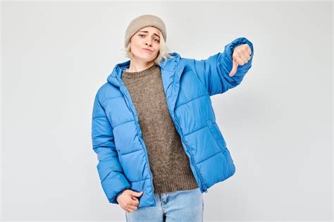 Portrait D Une Fille Blonde En V Tements D Hiver Bleus Montrant Les Pouces Vers Le Bas Isol E