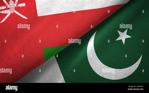 Oman And Pakistan Two Flags Textile Cloth Fabric Texture Stock Photo