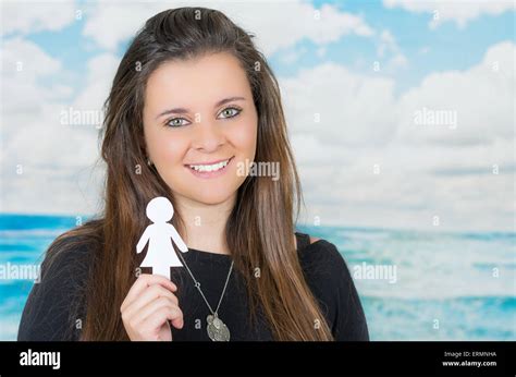 Brunette Holding An Origami Paper Figure In Front Of Oceanic Cloud Background Stock Photo Alamy