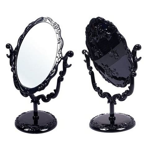 An Ornately Decorated Black Vanity Mirror With Stand On White Backgrounndg