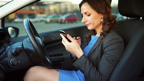 Woman In A Blue Dress And Jacket Using A Smartphone In The Car 22952079