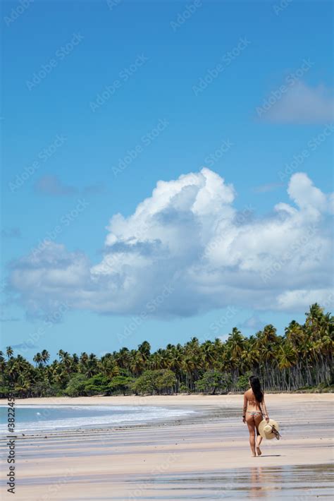 A Beautiful Athletic Hispanic Latin Woman In A Bikini With A Sun Hat On A Deserted Tropical