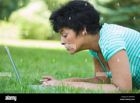 Side Profile Of A Mature Woman Lying On Grass And Using A Laptop Stock Photo Alamy