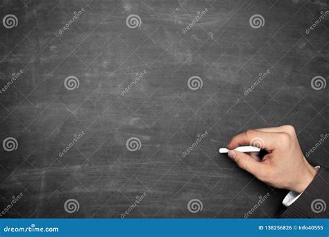 Businessman Hand Holding Chalk And Pointing On Blackboard Stock Photo