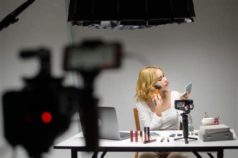 Hinter den Kulissen präsentiert eine junge blonde Unternehmerin mit einem Laptop arbeitet