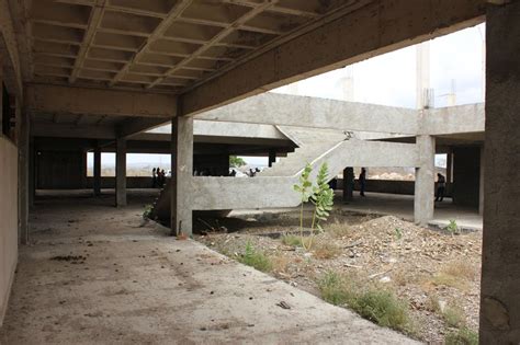 An Abandoned Building With People Walking Around It