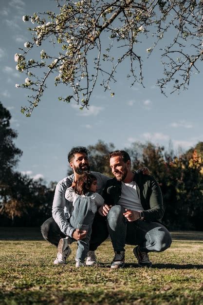 Una pareja gay masculina cuida a su pequeña hija en un parque concepto de familia moderna