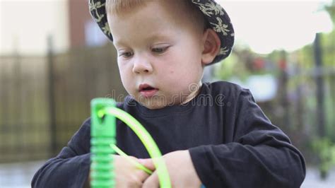 Funny Caucasian Child Kid Boy In Black Shirt And Hat Playing Outside