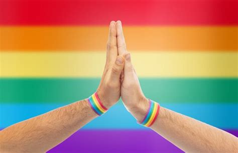 Premium Photo Hands With Gay Pride Wristbands Make High Five