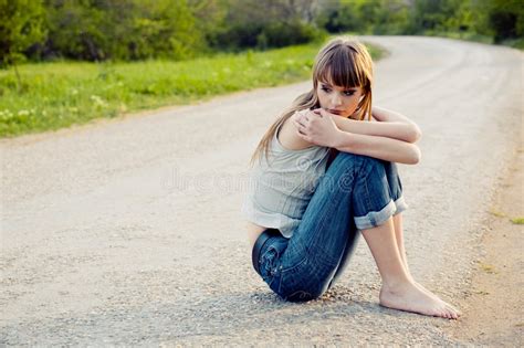 Menina Triste Do Jovem Adolescente Que Senta Se No Log Ao Longo Da