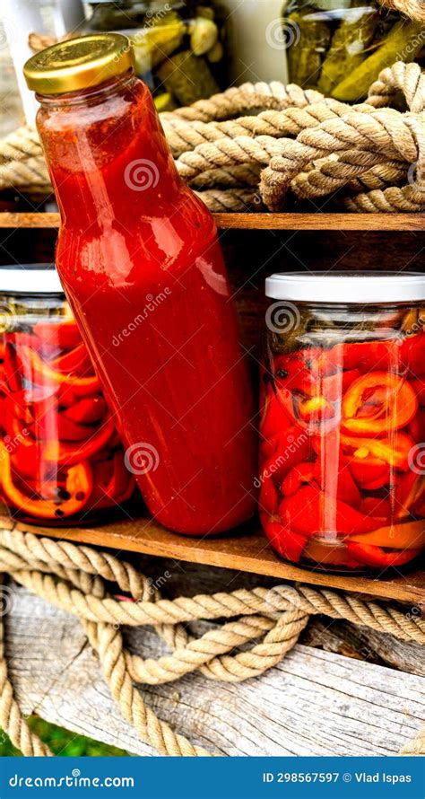 Wooden Crate With Bottles With Tomatoes Sauce And Glass Jars With