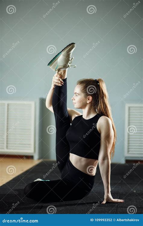 Beautiful Slim Brunette Doing Some Stretching Exercises In A Gym Stock Photo Image Of Athletic