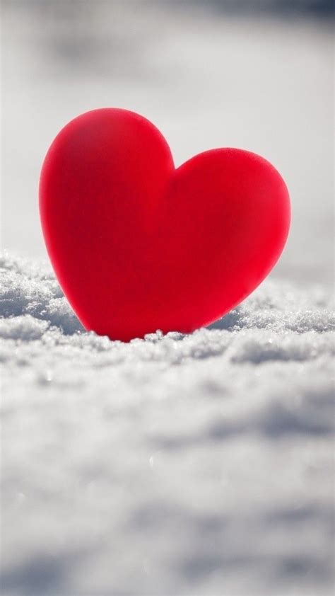 A Red Heart Sitting On Top Of Snow Covered Ground