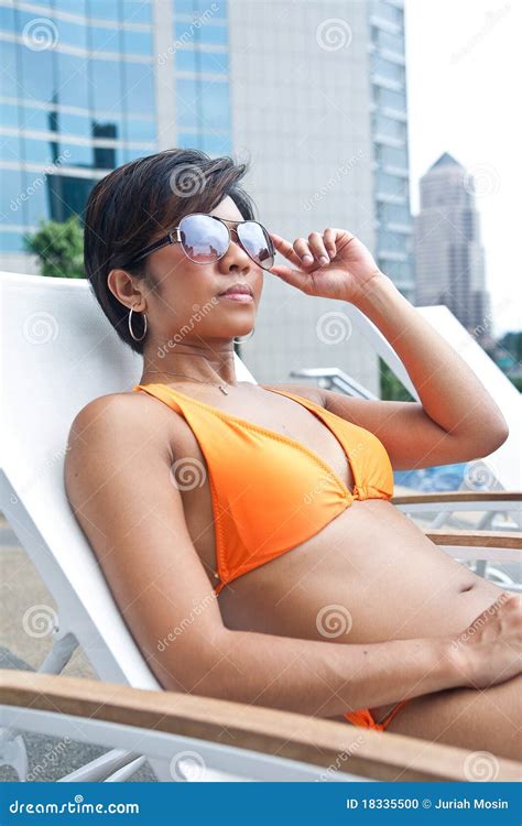 Asian Woman In Orange Bikini Relaxing By The Pool Stock Photo Image