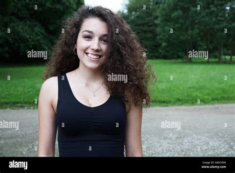 Schöne junge Frau mit brunette langes lockiges Haar in der Natur Stockfotografie Alamy
