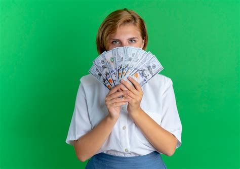 Jeune fille russe blonde confiante regarde l argent isolé sur fond vert avec copie espace